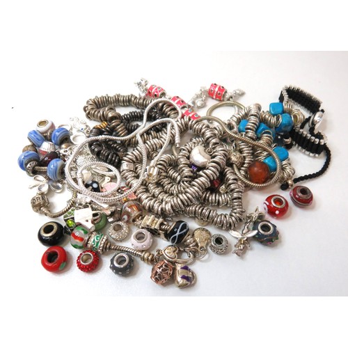 84 - Job lot of fashion charm bracelets and charms.