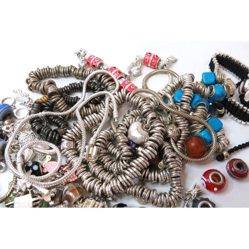 84 - Job lot of fashion charm bracelets and charms.