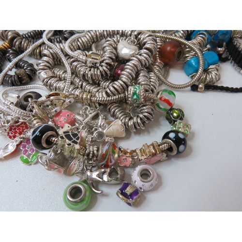 84 - Job lot of fashion charm bracelets and charms.