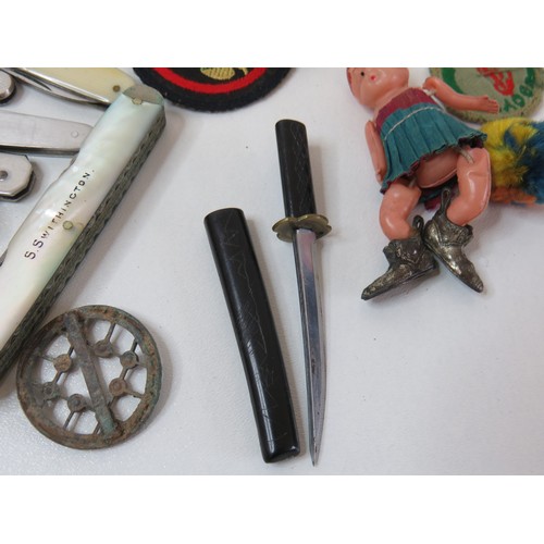 89 - Vintage tin with collectables includes penknives, cloth badges and miniature Samurai sword.