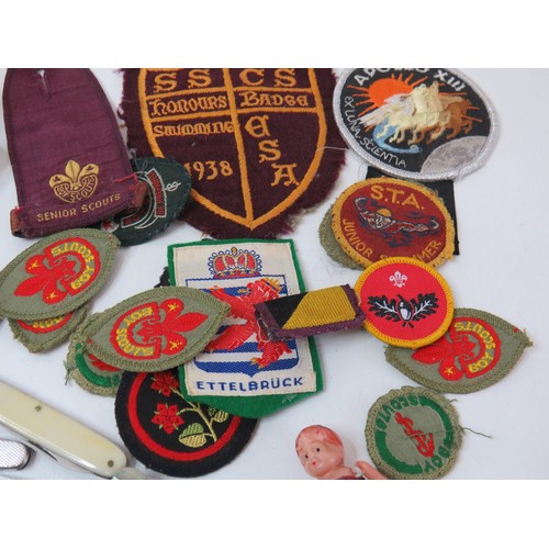 89 - Vintage tin with collectables includes penknives, cloth badges and miniature Samurai sword.