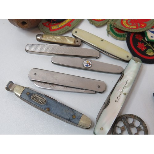 89 - Vintage tin with collectables includes penknives, cloth badges and miniature Samurai sword.