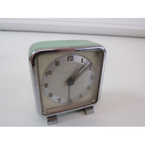 86 - A vintage Harrods of London travel alarm clock in green leather case good working condition.