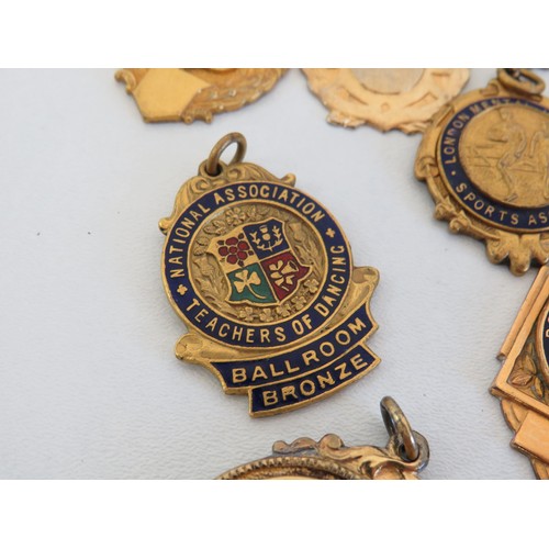90 - Collection of gold tone medals and fobs.