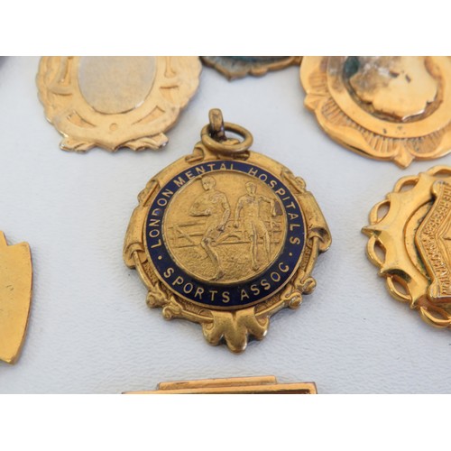 90 - Collection of gold tone medals and fobs.