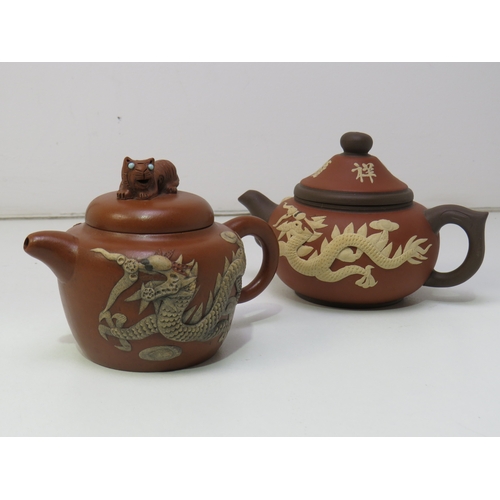 31 - Two antique Chinese clay Teapots with dragon relief decoration.