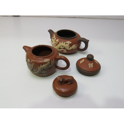 31 - Two antique Chinese clay Teapots with dragon relief decoration.