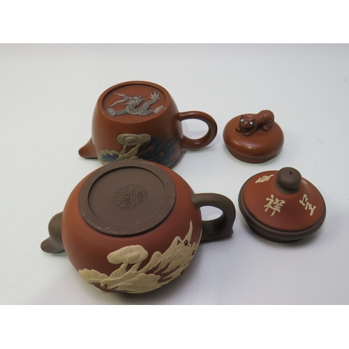31 - Two antique Chinese clay Teapots with dragon relief decoration.