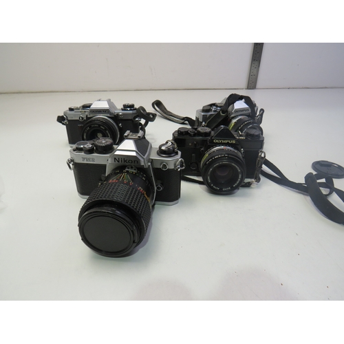 560 - Four vintage cameras to include Nikon FM2, Olympus OM-1, Olympus OM10 etc