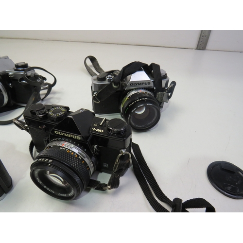 560 - Four vintage cameras to include Nikon FM2, Olympus OM-1, Olympus OM10 etc