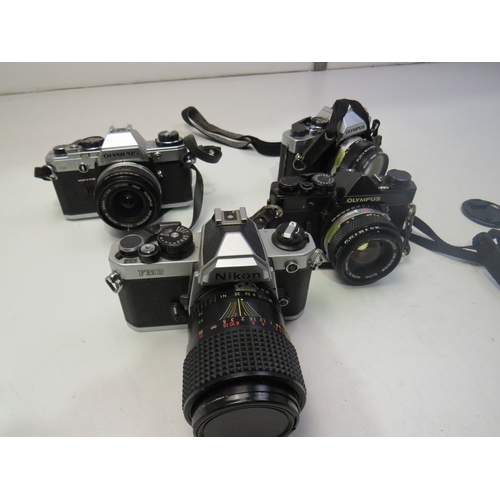 560 - Four vintage cameras to include Nikon FM2, Olympus OM-1, Olympus OM10 etc
