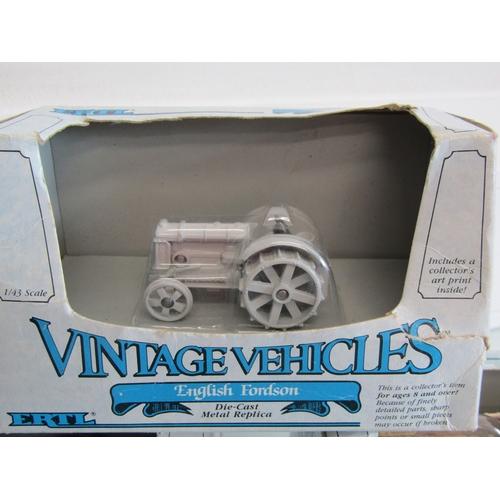 100 - A collection of eight boxed Ertl diecast metal tractors.