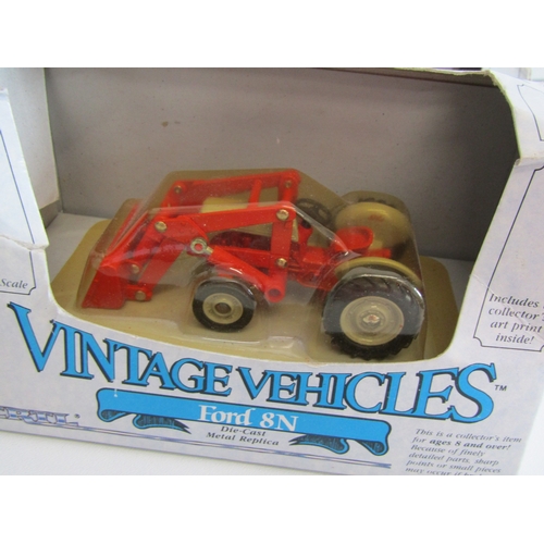 100 - A collection of eight boxed Ertl diecast metal tractors.