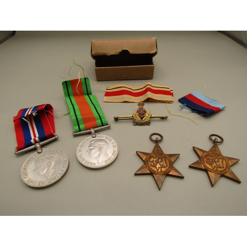 33 - Four WWII medals and a military pin badge with box