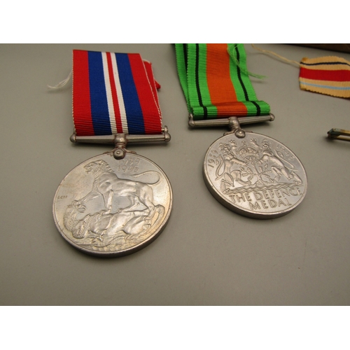 33 - Four WWII medals and a military pin badge with box