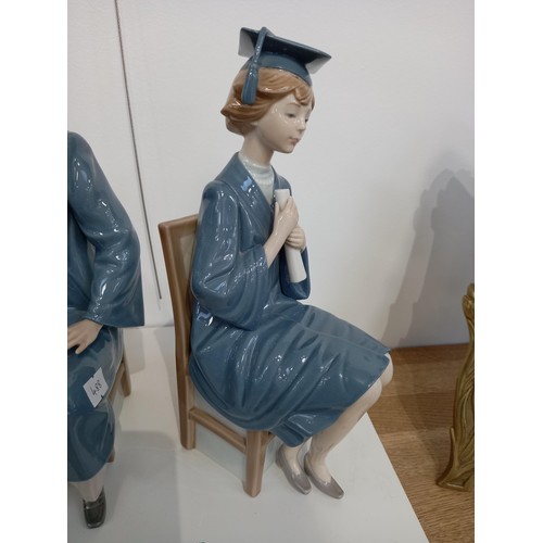 41 - Lladro male and female graduation figurines