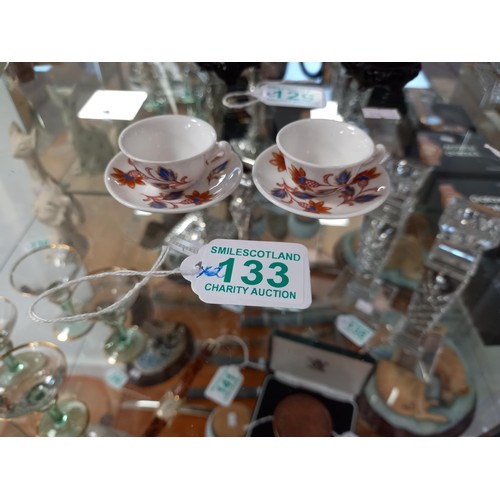 133 - Pair of miniature cups and saucers