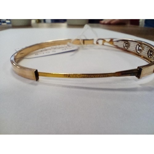 62 - 10ct gold bangle with US patent, stone mounted,  8g approx.