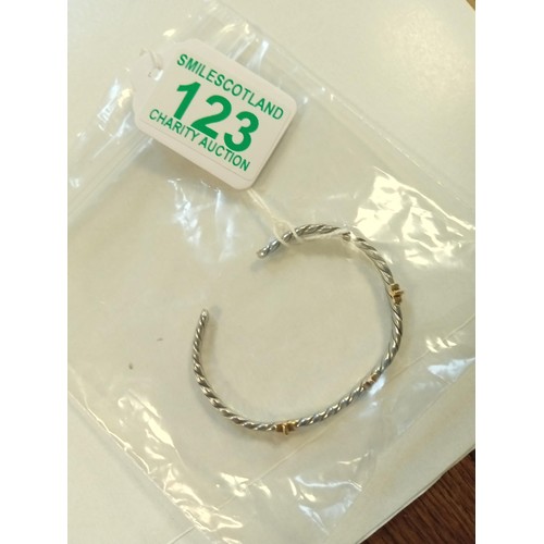 123 - Yellow and white metal cuff bangle with unclear marks