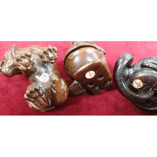 125 - 4x Netsukes (button fastener) with signatures skeleton, frog and snake, lion & a tied cat