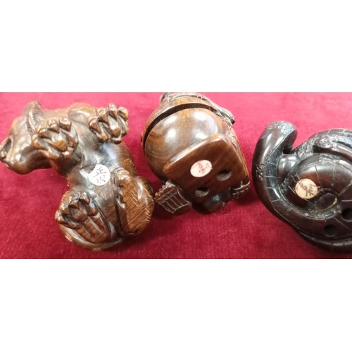 125 - 4x Netsukes (button fastener) with signatures skeleton, frog and snake, lion & a tied cat