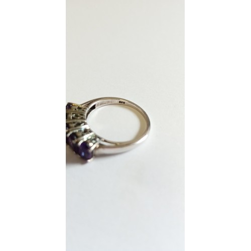 130 - Silver hallmarked and purple stone on a bridge ring size O approx.