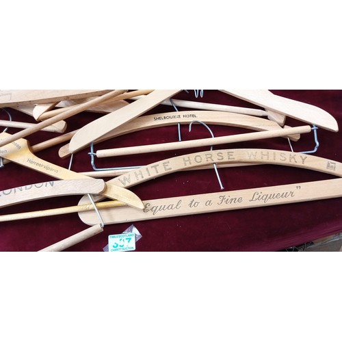 397 - Large selection of wooden coat hangers to include Savoy Hotel, White Horse Whisky, Woodstock hotel a... 