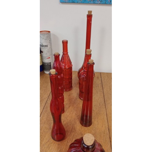 78 - Selection of red glass bottles