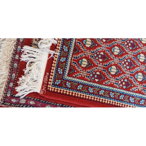 19 - Handmade Azerbaijan rug with red field dated 1990 and signed with geometric design 136cm x 62cm appr... 