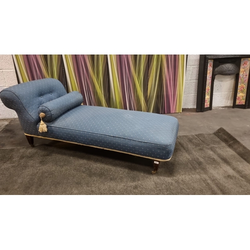 200 - Chaise lounge upholsteres in blue with god repeating pattern on castor wheel complete with bolster 1... 