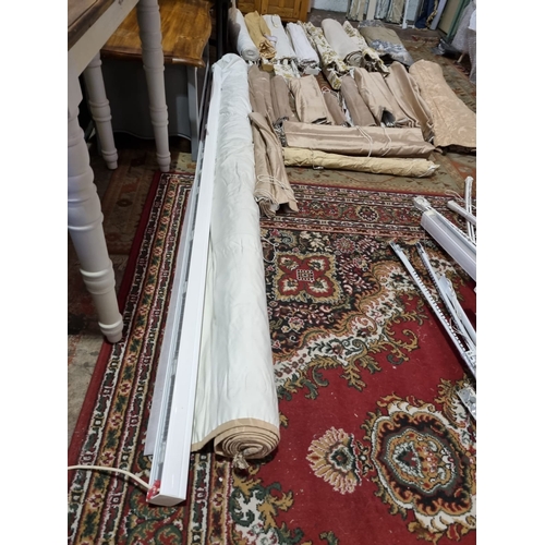 222 - A large selection of Roman blinds upholstered in various patterns complete with curtain poles and sl... 