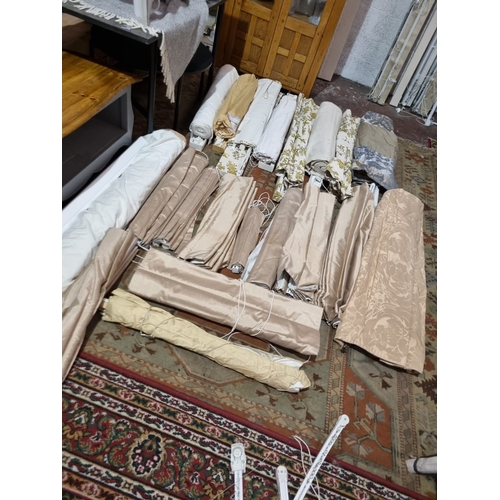 222 - A large selection of Roman blinds upholstered in various patterns complete with curtain poles and sl... 