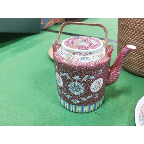 154 - Oriental teapot in fitted wicker basket with matching plate