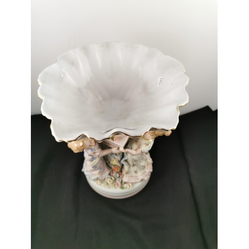 202 - An ornate ceramic figural bowl with three children holding a pillar in good condition with a cross s... 