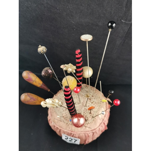 227 - Large Victorian pin cushion containing a large quantity of various types of hat pins
