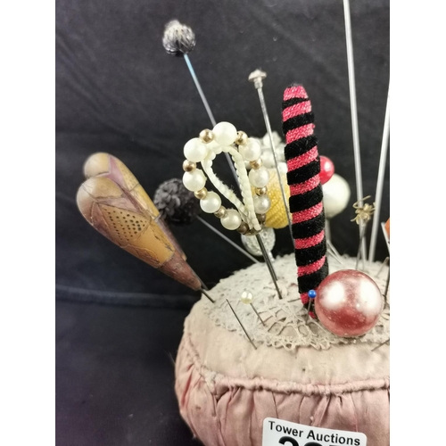 227 - Large Victorian pin cushion containing a large quantity of various types of hat pins