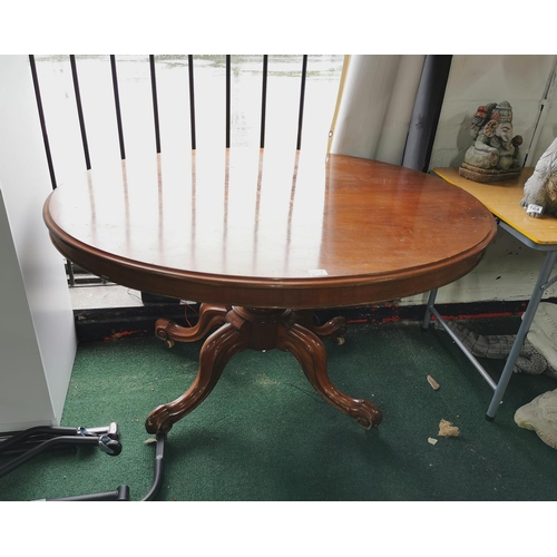 541 - Solid mahogany oval tilt top table on pedestal legs with porcelain castors, tilt top bolts need atte... 