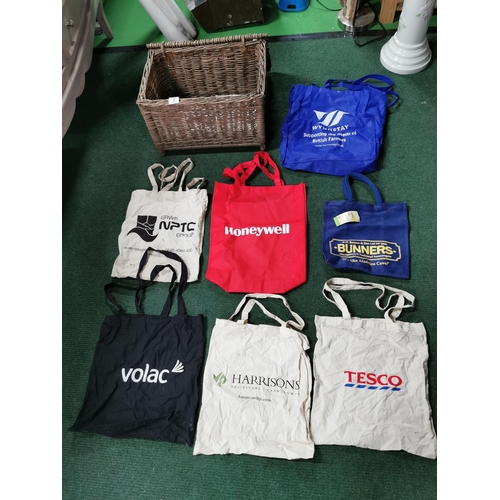 7 - Wicker hamper containing a quantity of cloth carrier bags inc a new Bunners of Montgomery Bag