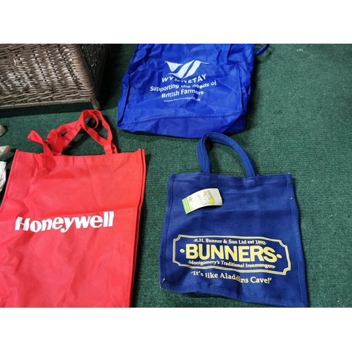 7 - Wicker hamper containing a quantity of cloth carrier bags inc a new Bunners of Montgomery Bag