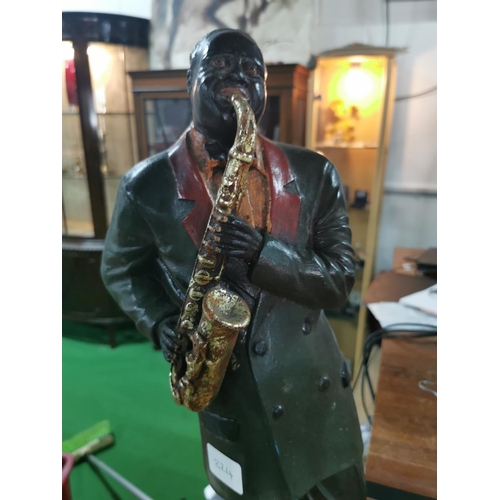 282 - Tall fiberglass figure of a jazz band player playing the saxophone, 57cm tall, 24cm wide