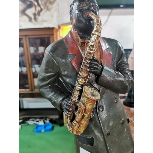 282 - Tall fiberglass figure of a jazz band player playing the saxophone, 57cm tall, 24cm wide