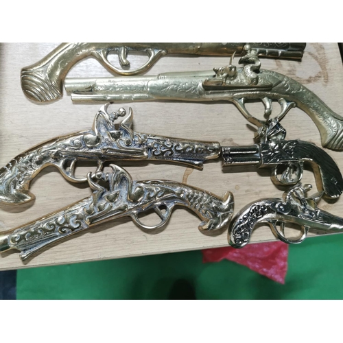 293 - Quantity of seven solid brass wall hanging decorative pistol's