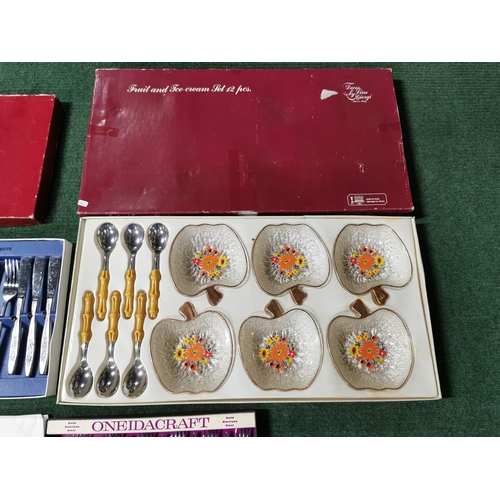 14 - Two cased cutlery sets  one by oneida along with a complete fruit and ice cream 12 person set