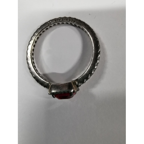 53 - Genuine Pandora ring inset with a large red stone and a quantity of clear stones all the way round t... 