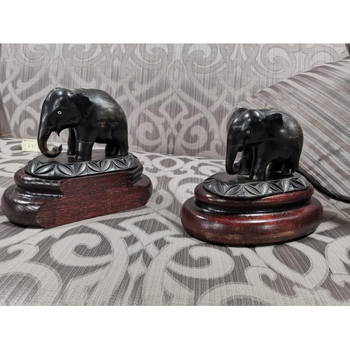 24 - 4 elephants, two resin, two ebony carved book ends. The book ends have old repairs, good detailing