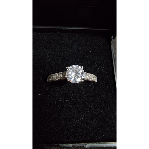 280 - Good 925 silver sparkly ring inset with a large CZ stone to the top flanked by CZ stones around the ... 