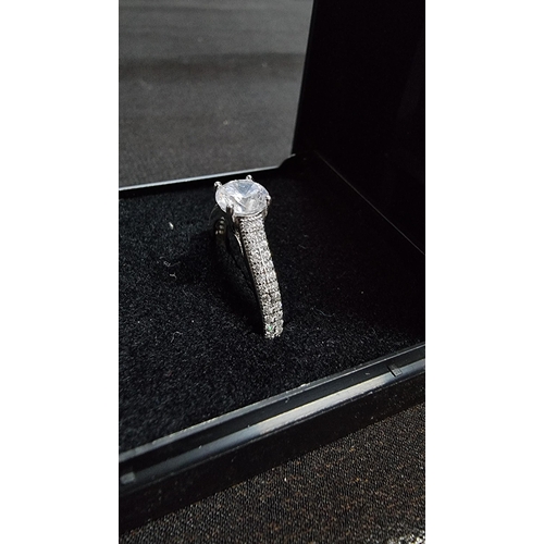 280 - Good 925 silver sparkly ring inset with a large CZ stone to the top flanked by CZ stones around the ... 