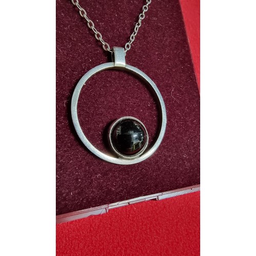 153 - White metal pendant and 16 inch chain with a black stone marked GEM
