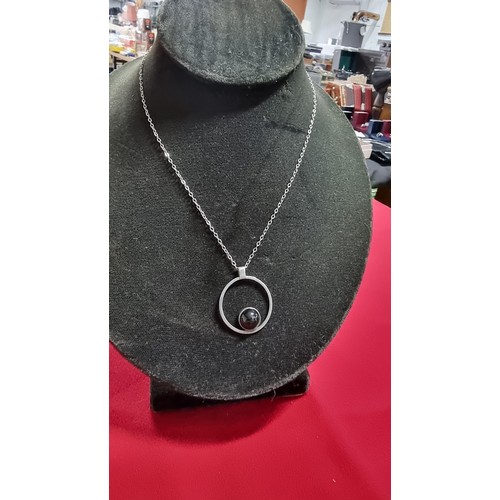 153 - White metal pendant and 16 inch chain with a black stone marked GEM