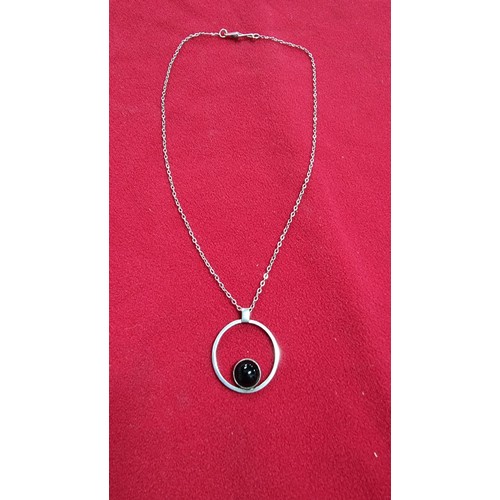 153 - White metal pendant and 16 inch chain with a black stone marked GEM